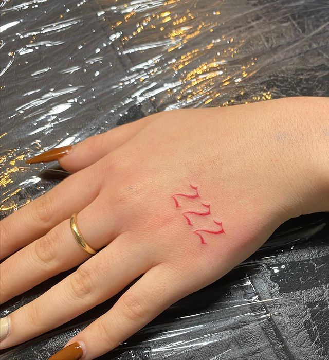 Number 222 tattoo located on the hand