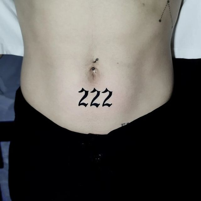 222 lettering tattoo located on the inner forearm